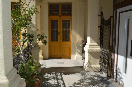 une porte jaune sur un bâtiment avec terrasse couverte dans l'établissement Synagogue Central Guest House, à Budapest