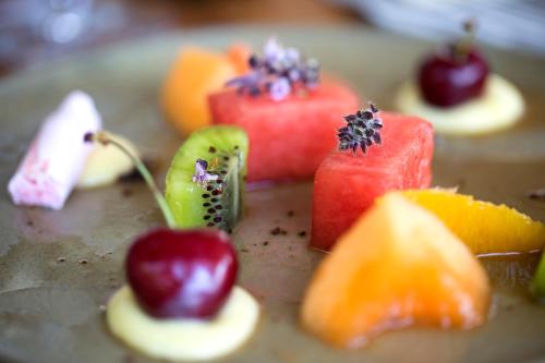 a bunch of fruit on a plate on a table at Hotel****Spa & Restaurant Cantemerle in Vence