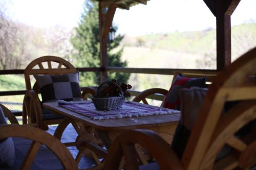 a wooden table with chairs on a porch at Forest Lodge on the Pyramid in Visoko
