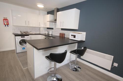 a kitchen with a counter and two stools at Fox Street Delight in Liverpool