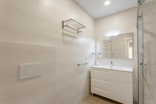 a white bathroom with a sink and a mirror at ApartUP Patacona Beach Select in Valencia