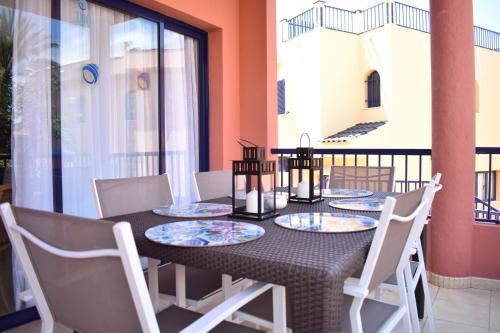una mesa de comedor con sillas blancas y una mesa con platos en TC Tríplex Bahía Meloneras, en Meloneras