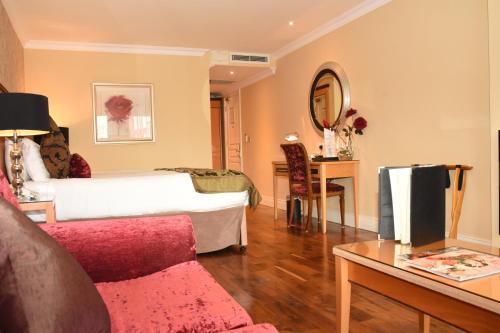 a bedroom with a bed and a table with a couch at The Fairview Boutique Hotel in Killarney