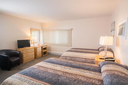 a hotel room with two beds and a desk at Trapper's Choice Inn & Restaurant in Parry Sound