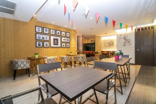 une salle à manger avec des tables, des chaises et des drapeaux dans l'établissement Aim House Bangkok No Parking, à Bangkok