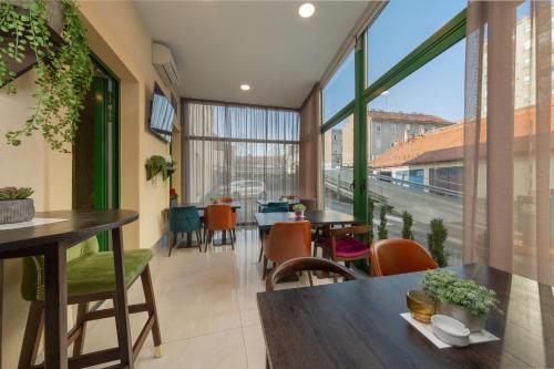 a room with tables and chairs and a large window at Hotel PARK 45 in Zagreb