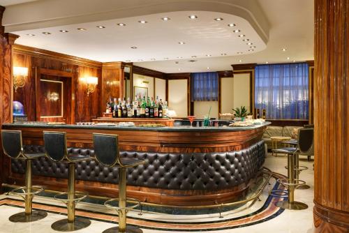 a bar in a hotel lobby with chairs and tables at UNA Hotels Scandinavia Milano in Milan