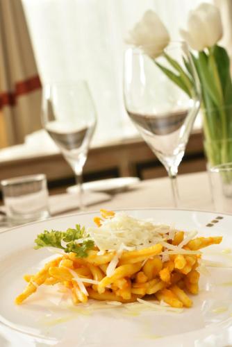 a plate of food on a table with wine glasses at UNA Hotels Scandinavia Milano in Milan