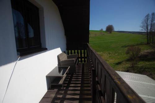 a balcony with benches and a view of a field at Apartmány Ve Mlejně in Čachrov
