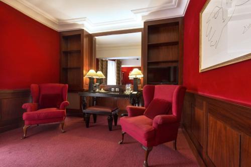 a red room with two chairs and a desk at Grand Hotel de l'Opera - BW Premier Collection in Toulouse