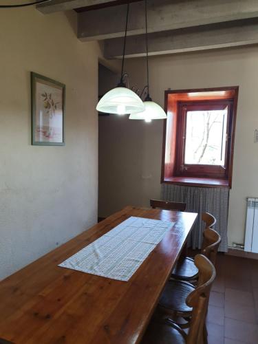 a dining room with a wooden table and a window at El Serrat Turisme Rural in Planoles
