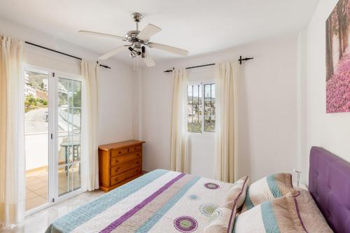 um quarto com uma cama e uma ventoinha de tecto em Villa Oliva Nerja - Private Pool - heated by Solar Panels em Nerja