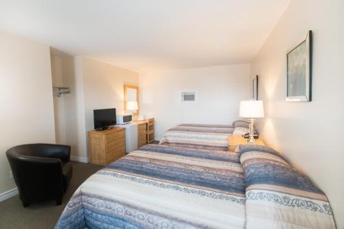 a hotel room with a bed and a television at Trapper's Choice Inn & Restaurant in Parry Sound