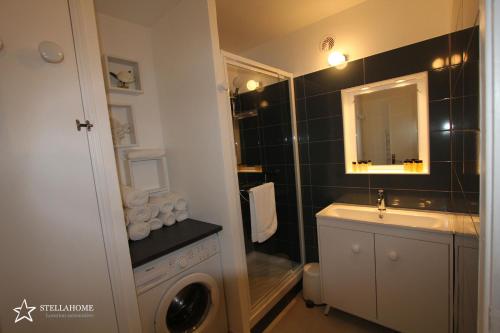 une salle de bain avec un lavabo et une machine à laver dans l'établissement StellaHome - L'Enclos, à Sanary-sur-Mer