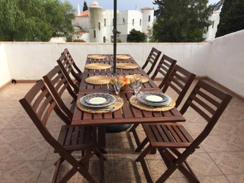 a wooden table with chairs and plates of food on it at Vivenda Jardim Mar Algarve Porches in Porches
