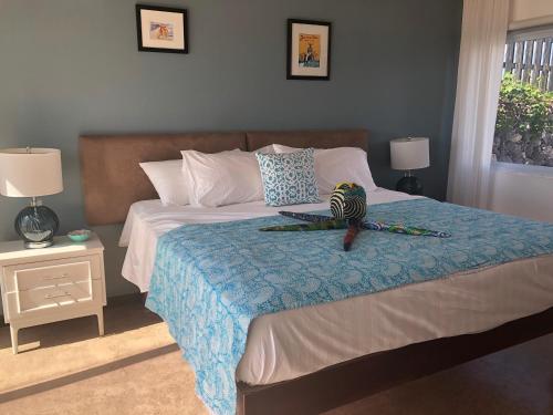 um quarto com uma cama com um pássaro sentado nela em Turtles Nest Villa em Treasure Beach