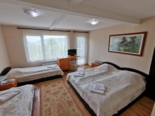 a room with three beds and a television in it at Villa Aqua in Pravets