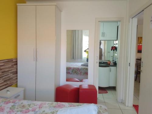 een slaapkamer met 2 bedden en een rode kruk bij Ponta Negra_Apto Completo in Natal