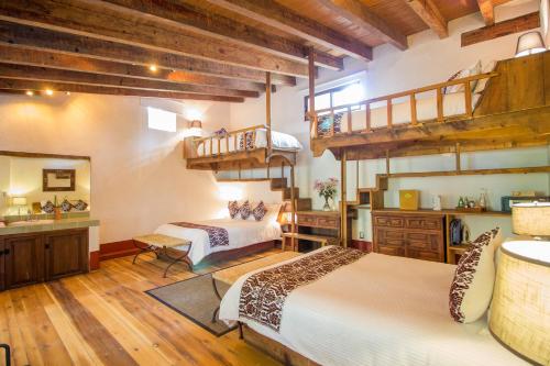 a bedroom with two beds and a loft at Mesón De Leyendas Breakfast & Downtown in Valle de Bravo