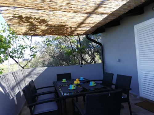 eine Terrasse mit einem Tisch und Stühlen auf dem Balkon in der Unterkunft Apartmani Zdenka Savar-Maslina in Savar