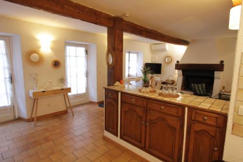 Il comprend une cuisine avec des placards en bois et une cheminée. dans l'établissement StellaHome - L'Enclos, à Sanary-sur-Mer