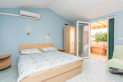 a bedroom with a bed and a balcony at Apartmani Albi in Zaton