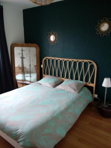 - une chambre avec un grand lit et un miroir dans l'établissement Maison de vacances cosy, à Avranches