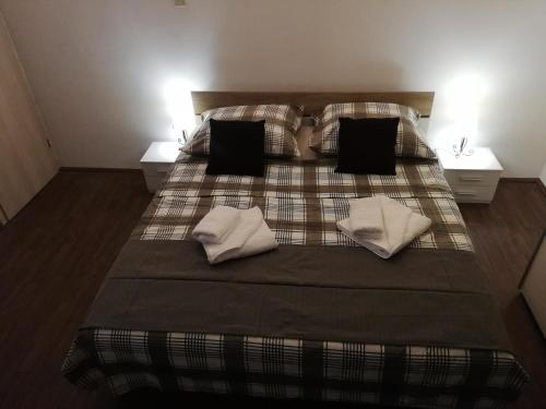 ein Schlafzimmer mit einem Bett mit zwei Kissen und zwei Tischen in der Unterkunft Apartmani Zdenka Savar-Maslina in Savar