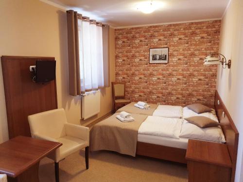 a bedroom with a bed and a brick wall at Hotel Zamkowy Młyn in Krapkowice
