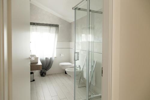 uma casa de banho com uma cabina de duche em vidro e um WC. em Luxury Apartment Lazise em Lazise