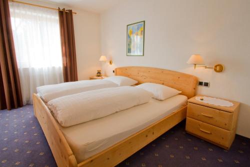 a bedroom with a large bed with a wooden frame at Haus Niederweg in Tirolo