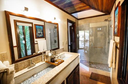 
a bathroom with a tub, sink and mirror at PUR Boutique Cabanas in San Pedro
