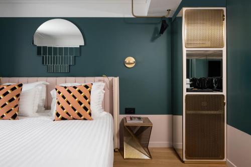 a bedroom with a bed and a blue wall at Hôtel Parisianer in Paris
