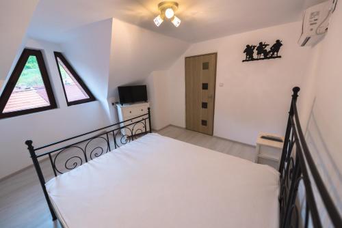 a bedroom with a bed in a room with windows at Casa Sky in Orşova