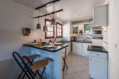 une cuisine avec des placards blancs et un comptoir bleu dans l'établissement Ferienwohnung „La Cigalerie“, à Agay