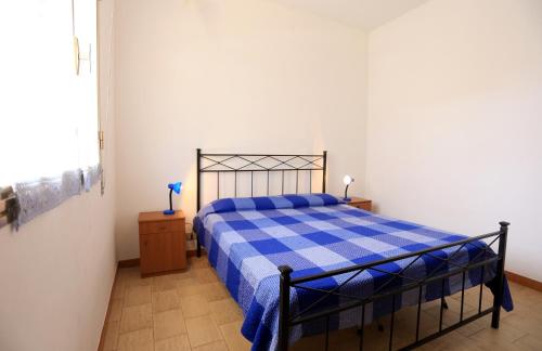 a bedroom with a blue and white bed in a room at Appartamento Lucilla in Punta Secca