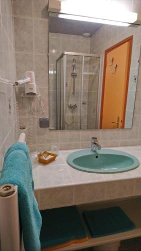 een badkamer met een wastafel, een douche en een spiegel bij L'Escale de Die in Die