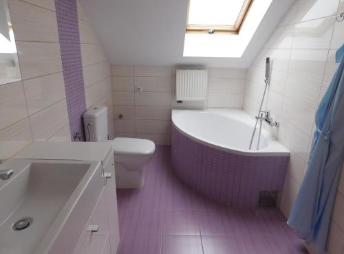 ein Badezimmer mit einer Badewanne, einem WC und einem Waschbecken in der Unterkunft Pokoje gościnne Barka in Wadowice