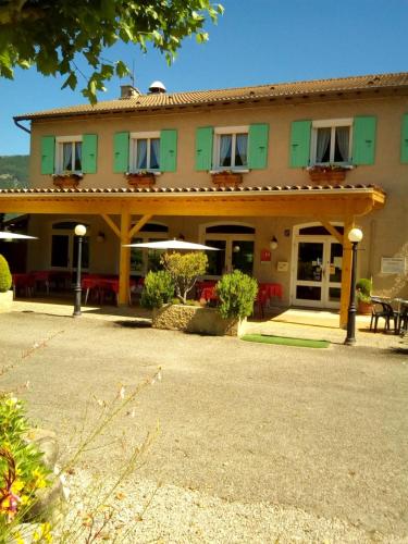 a large green building with tables and chairs at L'Escale de Die in Die