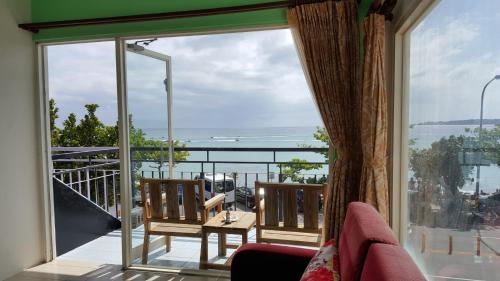 a room with a balcony with a view of the ocean at Hearty Homestay in Nanwan