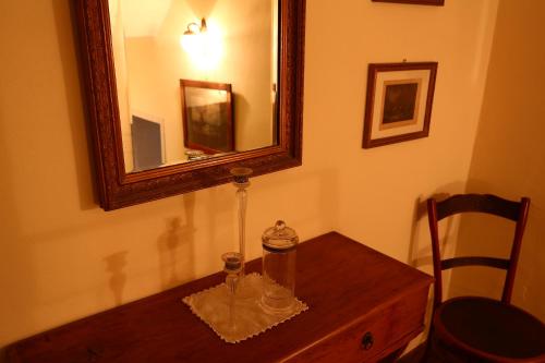 a mirror on top of a wooden table in a room at Residenza La Dimora ImPerfetta in Salionze