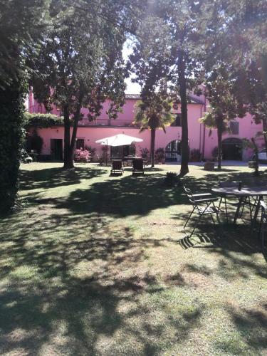 a park with picnic tables and trees in front of a building at Residenza La Dimora ImPerfetta in Salionze