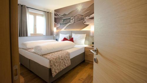 una piccola camera con letto e finestra di BLUE MOON APARTMENTS a Livigno