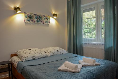 sypialnia z łóżkiem z dwoma ręcznikami w obiekcie Apartamenty Asturia w Rymanowie-Zdroju