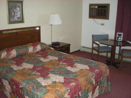 um quarto de hotel com uma cama e uma mesa em American Motel Waseca em Waseca