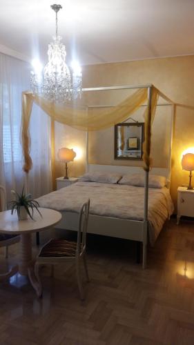a bedroom with a bed and a table and a chandelier at La Martino B&B in Varese