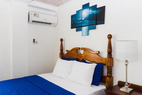 a bedroom with a bed with blue and white sheets at Calliandras Apartment Complex in Kingstown