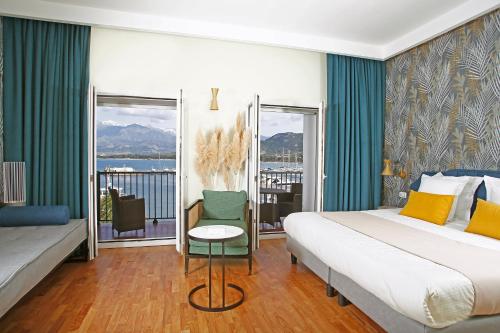 a bedroom with a bed and a couch and a window at Hotel Balanea in Calvi