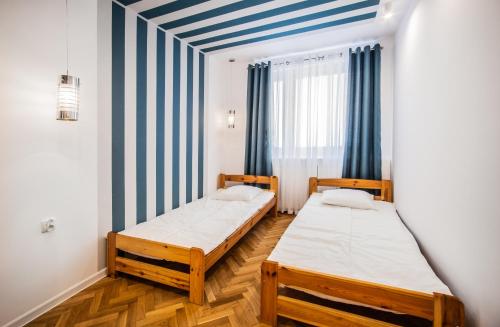 two beds in a room with blue and white stripes at Apartament w Centrum II in Ustka