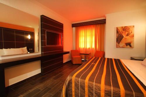 a hotel room with a bed and a flat screen tv at Motel Mirage in Guadalajara